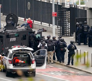 NYPD emergency services officers respond to a man standing outside United Nations headquarters with a shotgun, Thursday, Dec. 2, 2021, in New York. Hostage negotiators spoke to the man who appeared to be in his 60s, and hoped to resolve the situation peacefully.