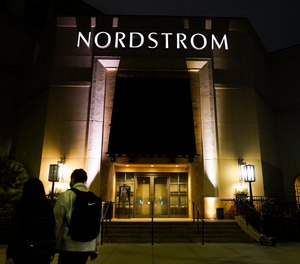 Two pedestrians walk near a closed street entrance to a Nordstrom department store at the Grove mall in Los Angeles, Thursday, Dec. 2, 2021, where a recent smash-and-grab robbery took place.
