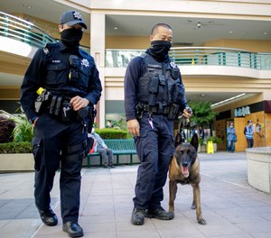 Police officers patrol through the Pacific Renaissance Plaza in Oakland's Chinatown, in Calif., on Tuesday, Dec. 7, 2021.