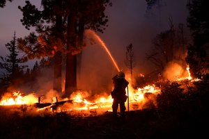 Firefighter Elroy Valadez sprays water over a spot fire from the Caldor Fire in this file photo from Sept. 2.