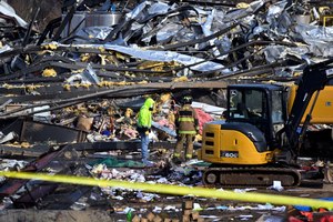 Emergency response workers dug through the rubble of the Mayfield Consumer Products candle factory in Mayfield, Ky., on Saturday.
