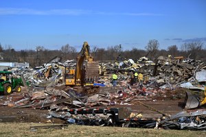 Emergency response workers dug through the rubble of the Mayfield Consumer Products candle factory in Mayfield, Ky.,  on Saturday.