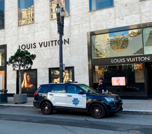 Police officers and emergency crews park outside the Louis Vuitton store in San Francisco's Union Square on Nov. 21, 2021, after looters ransacked businesses.