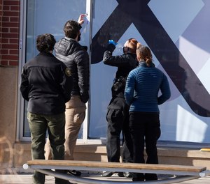Investigators recover evidence from a window frame outside an Xfinity store Tuesday, Dec. 28, 2021, in Lakewood, Colo., one of the scenes of a shooting spree that left several people dead—including the suspected shooter Monday evening—and left a few more people wounded.