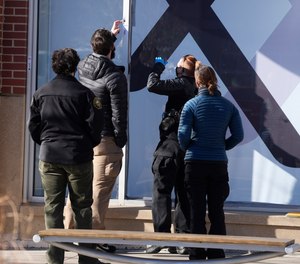 Investigators recover evidence from a window frame outside an Xfinity store Tuesday, Dec. 28, 2021, in Lakewood, Colo., one of the scenes of a shooting spree that left several people dead—including the suspected shooter Monday evening—and left a few more people wounded.