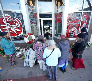 Mourners gather outside a tattoo parlor Tuesday, Dec. 28, 2021 in Denver, one of the scenes of a shooting spree that left six people dead—including the suspected shooter Monday evening—and left two more wounded.