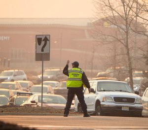 Broomfield Police direct motorists during an evacuation as a wildfire burns near a shopping center Thursday, Dec. 30, 2021, near Broomfield, Colo. Homes surrounding the Flatiron Crossing mall were being evacuated as wildfires raced through the grasslands as high winds raked the intermountain West.