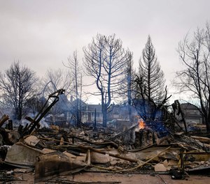 A fire still burns in a home destroyed by the Marshall Wildfire in Louisville, Colo., Friday, Dec. 31, 2021.