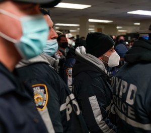 NYPD officers listen to a briefing before a raid in the Brooklyn borough of New York, Tuesday, Jan. 4, 2022.