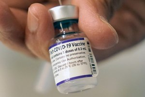 A doctor loads a dose of the Pfizer COVID-19 vaccine into a syringe on Dec. 2 at a mobile vaccination clinic in Worcester, Mass.