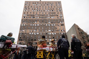 Emergency personnel work at the scene of a fatal fire at an apartment building in the Bronx on Sunday, Jan. 9, 2022, in New York.