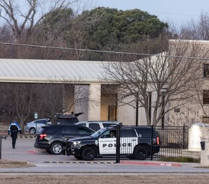 Police stand in front of the Congregation Beth Israel synagogue, Sunday, Jan. 16, 2022, in Colleyville, Texas. A man held hostages for more than 10 hours Saturday inside the temple. The hostages were able to escape and the hostage taker was killed.