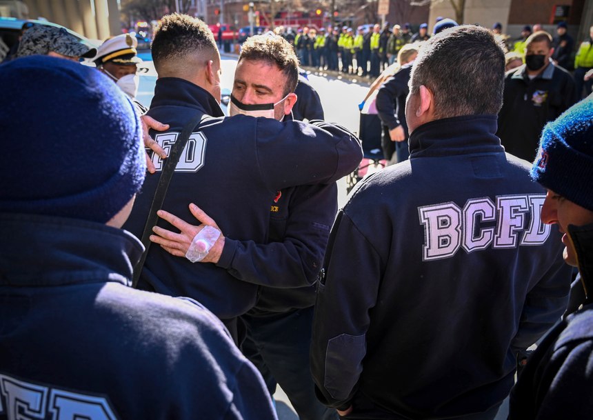 Baltimore firefighter John McMaster, center, who was injured in the fire and building collapse on Stricker Street on Monday hugs fellow firefighters who were there to greet him as he was released from Shock Trauma on Thursday.