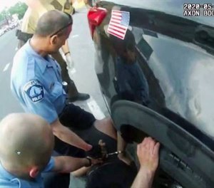 A screenshot from bodycam video shows paramedics arrive as Minneapolis police officers, including Derek Chauvin, second from left, and J. Alexander Kueng restrain George Floyd in Minneapolis, on May 25, 2020.