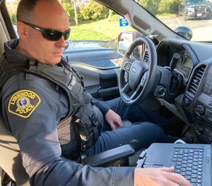 Lynnwood police Officer Denis Molloy works in his vehicle, Wednesday, Nov. 17, 2021, in Lynnwood, Wash.