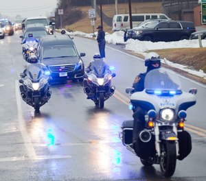 Over a dozen law enforcement agencies form a police escort of the bodies of Bridgewater Police Officer John E. Painter and Bridgewater Safety Officer J.J. Jefferson on Thursday, Feb. 3, 2022, in Roanoke, Va.