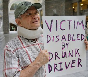 In this March 17, 2017, file photo, Ed Staley holds a sign during a rally at the Utah State Capitol in Salt Lake City. Car crashes and traffic deaths decreased in Utah the after state enacted the strictest drunken driving laws in the nation. A study published, Friday, Feb. 11, 2022, by the National Highway Traffic Safety Administration suggests Utah's roads became safer after the state lower the drunken driving threshold to .05% blood-alcohol content.