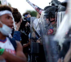 Demonstrators face members of the Austin Police Department as they gather in downtown Austin, Texas, on June 4, 2020, to protest the death of George Floyd