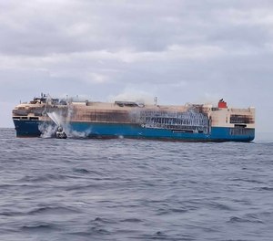 In this undated photo provided by the Portuguese Navy, smoke billows from the burning Felicity Ace car transport ship as seen from the Portuguese Navy NPR Setubal ship southeast of the mid-Atlantic Portuguese Azores Islands. The ship's crew were taken by helicopter to Faial island on the archipelago, about 170 kilometers (100 miles) away on Wednesday, Feb. 16, 2022. There were no reported injuries.
