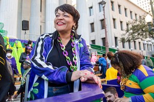 New Orleans Mayor LaToya Cantrell is seen smiling on the steps of Gallier Hall as the Krewe of Freret parade passed viewing stands on Feb. 19, 2022.