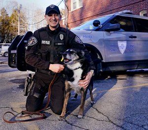 Rhode Island State Police Cpl. Daniel O'Neil poses with his partner, Ruby, a working state police K-9 and former shelter dog, outside the state police barracks in North Kingstown, R.I., on Feb. 16. The Australian shepherd and border collie mix will be featured in a Netflix movie titled 
