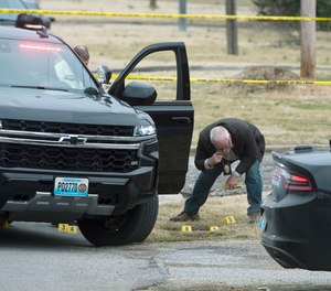 Investigators place evidence markers at the site of shootout that left two police officers dead and a third wounded on Tuesday, March 8, 2022 in Joplin, Mo.