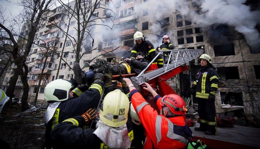 In this photo released by Ukrainian State Emergency Service press service, firefighters evacuate a man from an apartment building hit by shelling in Kyiv, Ukraine, Monday, March 14, 2022. 