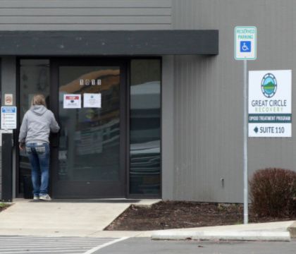 A woman enters the Great Circle drug treatment center in Salem, Oregon. The center gets funding from Oregon's drug decriminalization law and illustrates an aspect of the new system, one year after it took effect.