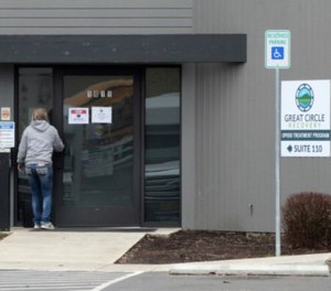 A woman enters the Great Circle drug treatment center in Salem, Oregon. The center gets funding from Oregon's drug decriminalization law and illustrates an aspect of the new system, one year after it took effect.