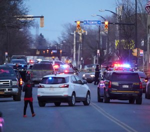 Police gather at the scene of a shooting where three police officers were shot in Buffalo, N.Y., Tuesday, March 29, 2022.