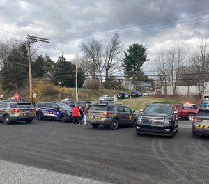 Police gather near the scene where a Pennsylvania police officer was killed and two others injured during a shooting that occurred while responding to a domestic disturbance call Thursday, March 31, 2022.