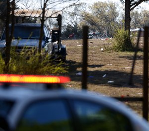 A police car sits in front of the scene, Sunday, April, 3, 2022, where a man was fatally shot and at least 11 other people were injured in connection to a shooting Saturday night at a concert in Dallas, Texas.