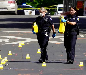 Sacramento Police officers place evidence markers during the investigation of a mass shooting In Sacramento, Calif., April 3, 2022.