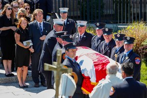 Patrick and Dee Dee Klein, parents of late New York City Firefighter Timothy Klein, follow his casket as it is carried out of St. Francis DeSales Church during a funeral service, Friday.