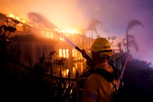 A firefighter battles a structure fire Wednesday in Laguna Niguel, Calif.