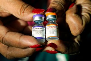 A nurse holds a vial of the Pfizer COVID-19 vaccine for children ages 5 to 11 (right) and a vial of the vaccine for adults, which has a different colored label, at a vaccination station in Jackson, Miss., on Feb. 8, 2022.