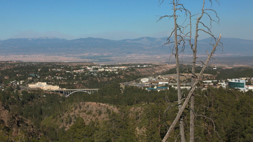 A haze of wildfire smoke hangs over the Upper Rio Grande valley behind the mesa-top city of Los Alamos, N.M. Public schools and many businesses were closed as a wildfire crept closer to the city and companion national security laboratory. Scientists at Los Alamos National Laboratory are using supercomputers and ingenuity to improve wildfire forecasting and forest management amid drought and climate change in the American West.