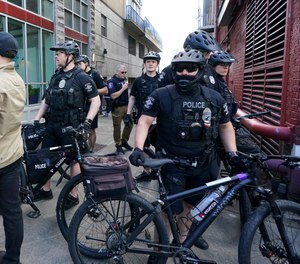 Seattle police officers patrol on bikes on Saturday, May 14, 2022.