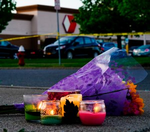Flowers and candles lay outside the scene of a shooting at a supermarket, in Buffalo, N.Y., Sunday, May 15, 2022