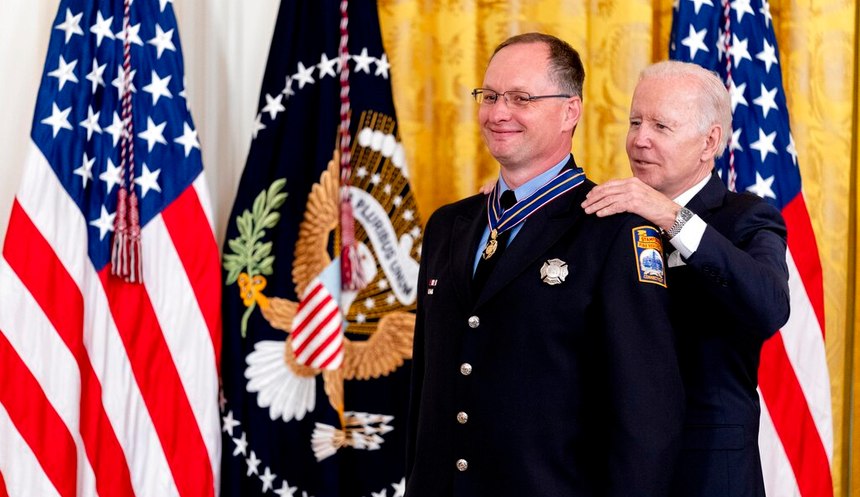 President Joe Biden awards Firefighter Chad Titus the Public Safety Officer Medal of Valor in the East Room of the White House.