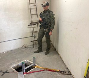 A law enforcement officer stands by the opening of a cross-border tunnel on Monday, May 16, 2022 between Mexico's Tijuana into the San Diego area.