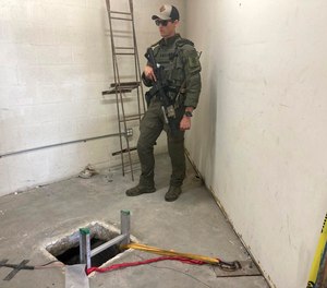 A law enforcement officer stands by the opening of a cross-border tunnel on Monday, May 16, 2022 between Mexico's Tijuana into the San Diego area.