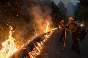 Firefighters monitor a controlled burn along Nacimiento-Fergusson Road to help contain the Dolan Fire near Big Sur, Calif., in 2020.