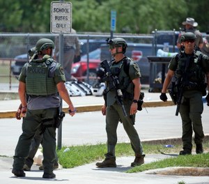 Law enforcement personnel stand outside Robb Elementary School following a shooting, Tuesday, May 24, 2022, in Uvalde, Texas.