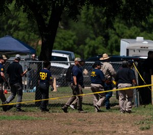 Investigators walk across a school yard at Robb Elementary School in Uvalde, Texas, Wednesday, May 25, 2022.