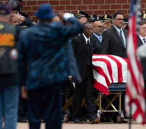 Pallbearers wheel the casket of Aaron Salter Jr. during a funeral service.