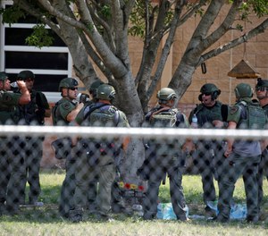 Law enforcement personnel stand outside Robb Elementary School following a shooting, Tuesday, May 24, 2022, in Uvalde, Texas.