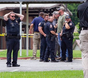 Officials gather outside Walnut Park Elementary School in Gadsden, Ala., following a fatal police shooting on Thursday, June 9, 2022. Authorities say a man who tried to enter an Alabama elementary school where a summer program was being held was shot to death by police.