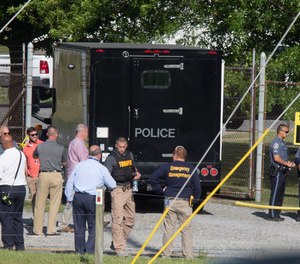 Law enforcement officials gather outside the entrance to Columbia Machine Inc on Thursday, June 9, 2022 near Smithsburg, Md., after an employee opened fire, killing three coworkers and wounding a state trooper.