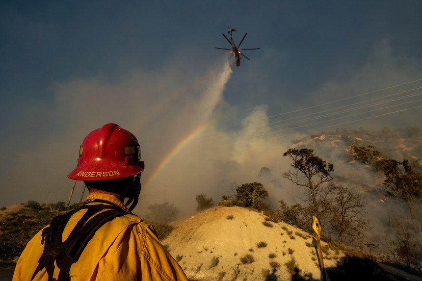 A firefighter watches as the Sheep Fire burns in Wrightwood, Calif., Sunday, June 12, 2022.